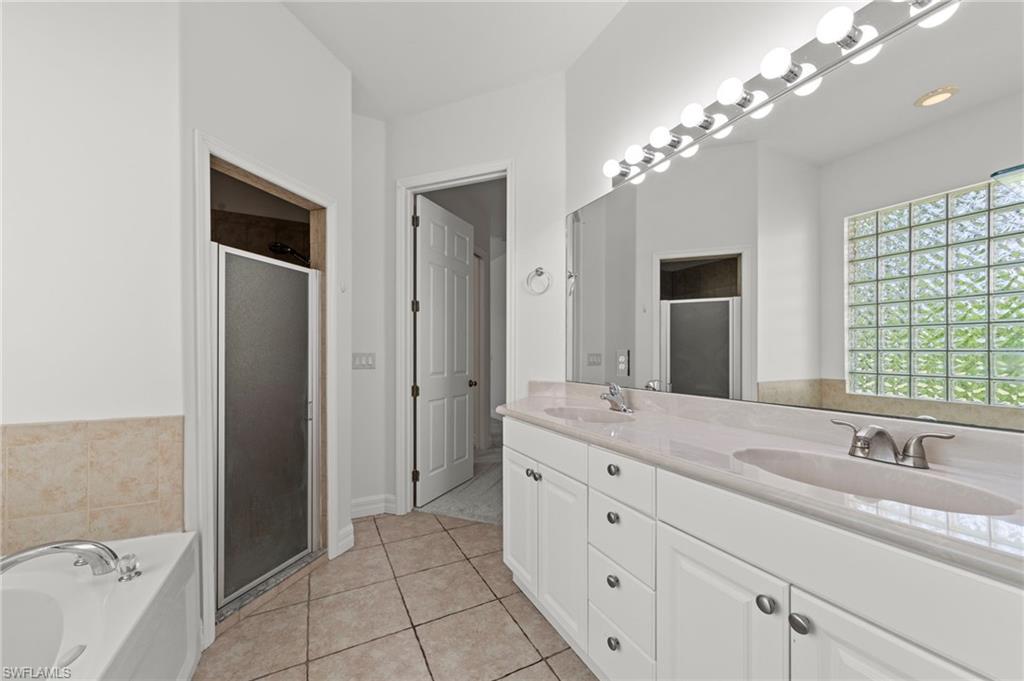 9623 Springlake Circle Estero, FL 33928 - Photo 25 of 47 a spacious bathroom with a granite countertop sink a toilet a mirror a bathtub and shower