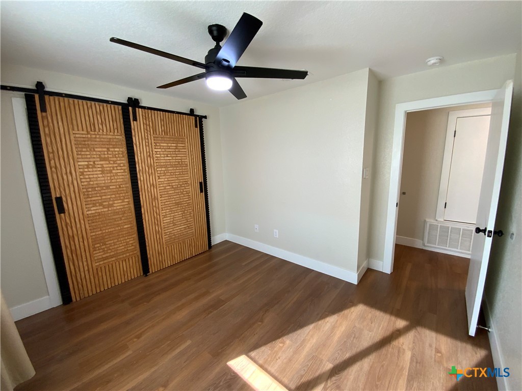 4725 Hartrick Bluff Road Temple, TX 76502 - Photo 17 of 27 an empty room with wooden floor and windows