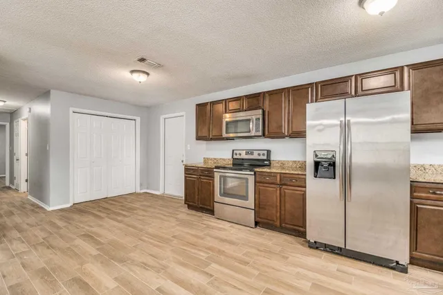 a kitchen with a refrigerator and a stove top oven