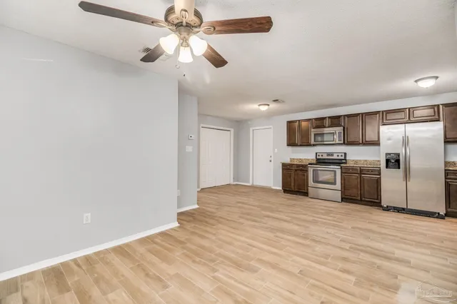 a view of kitchen with a sink stainless steel appliances and cabinets