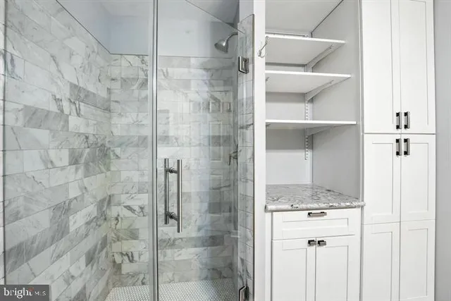 a bathroom with a granite countertop shower and a sink
