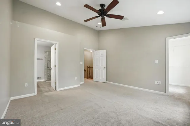 an empty room with closet and a ceiling fan
