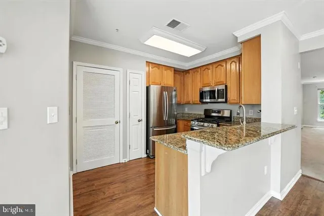 a kitchen with stainless steel appliances granite countertop a refrigerator stove microwave and sink