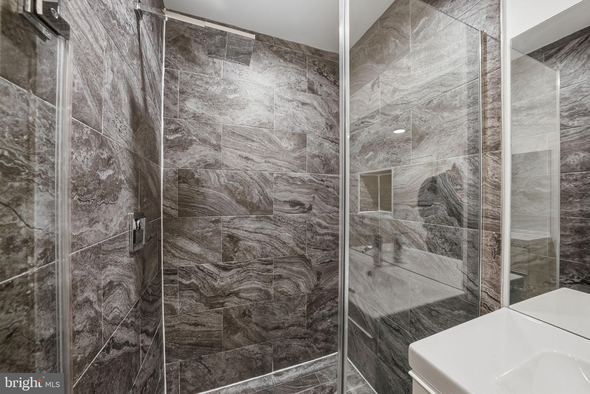 1512 F Street Northeast, Unit 2 Washington, DC 20002 - Photo 24 of 37 Sleek modern shower with elegant stone tiles.