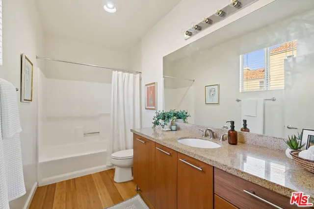 a bathroom with a sink a toilet a shower and a mirror