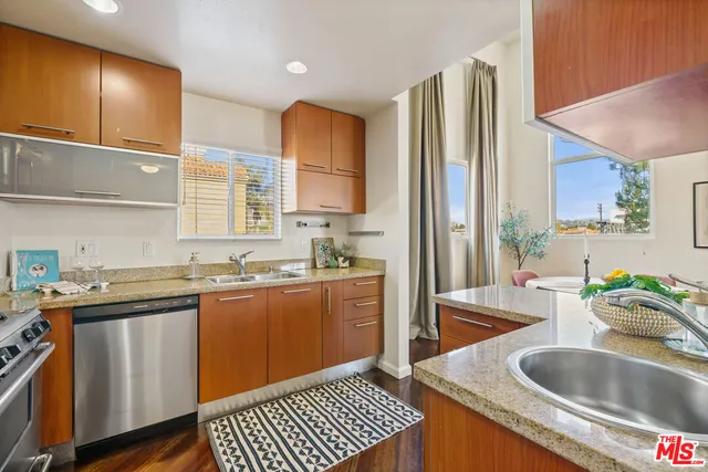a kitchen with stainless steel appliances granite countertop a sink stove and cabinets