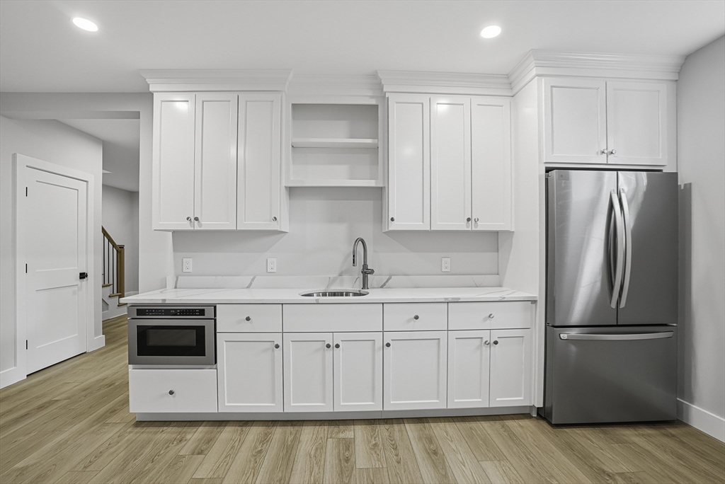 18 Avon Circle Needham, MA 02494 - Photo 16 of 18 a kitchen with white cabinets white stainless steel appliances and sink