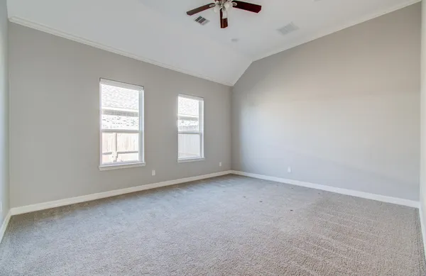 an empty room with windows and fan