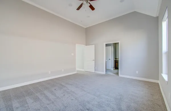 an empty room with closet and a ceiling fan