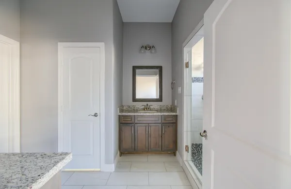 a bathroom with a granite countertop sink a mirror and a bathtub