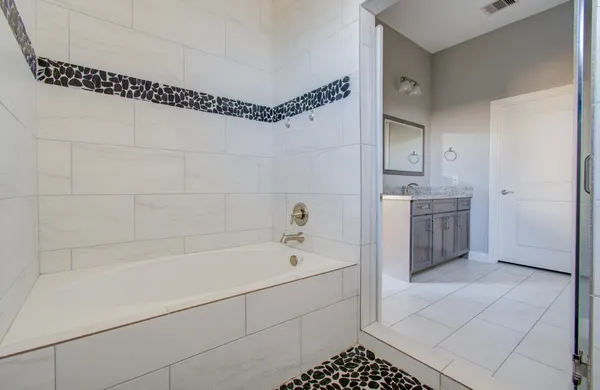 a spacious bathroom with a tub a sink and a shower