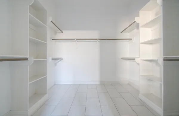 a view of walk in closet with empty racks