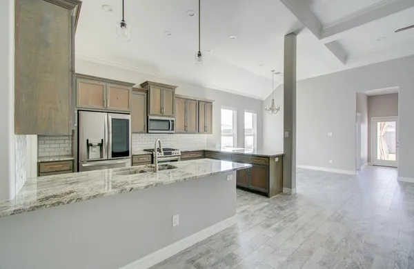 a kitchen with stainless steel appliances granite countertop a sink refrigerator and cabinets
