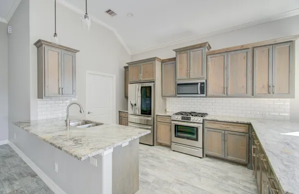 a kitchen with granite countertop stainless steel appliances and white cabinets