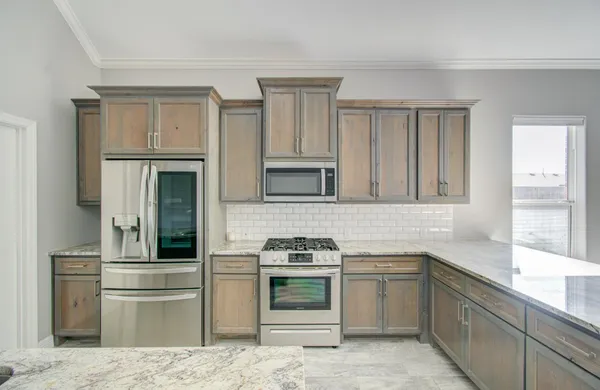 a kitchen with stainless steel appliances granite countertop a refrigerator and a sink