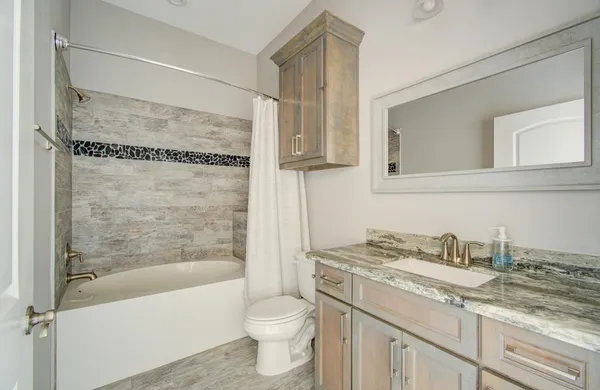 a bathroom with a granite countertop sink toilet and shower