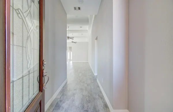 a view of a hallway with wooden floor