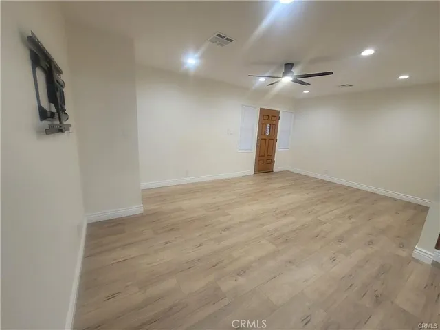 en empty room with ceiling fan and window