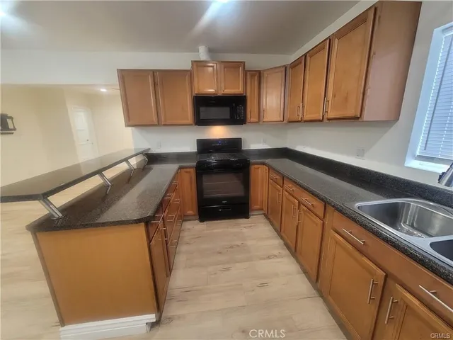a kitchen with granite countertop sink stainless steel appliances and cabinets