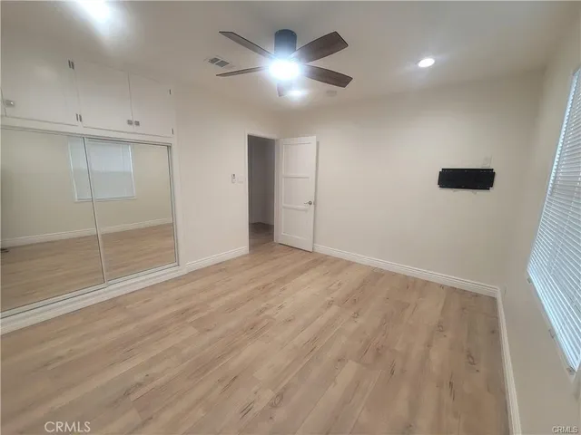 an empty room with fan and entrance