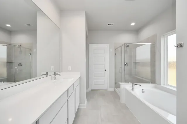a spacious bathroom with a double vanity sink mirror and double