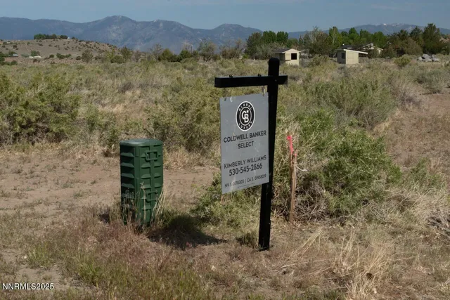 a view of a wooden house with a mountain and trees in the background