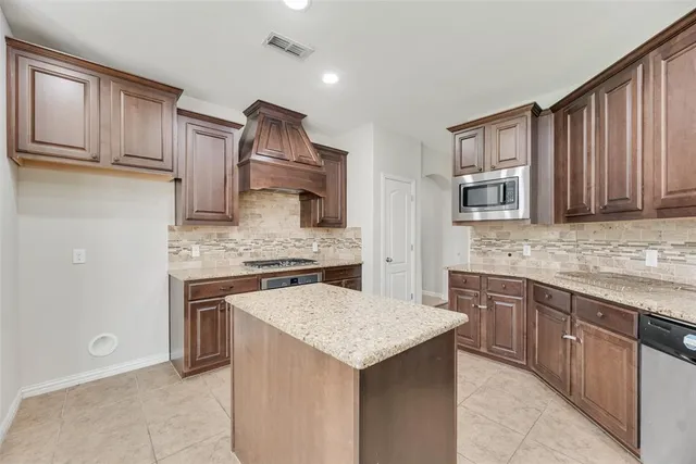 a kitchen with stainless steel appliances granite countertop a stove and a sink