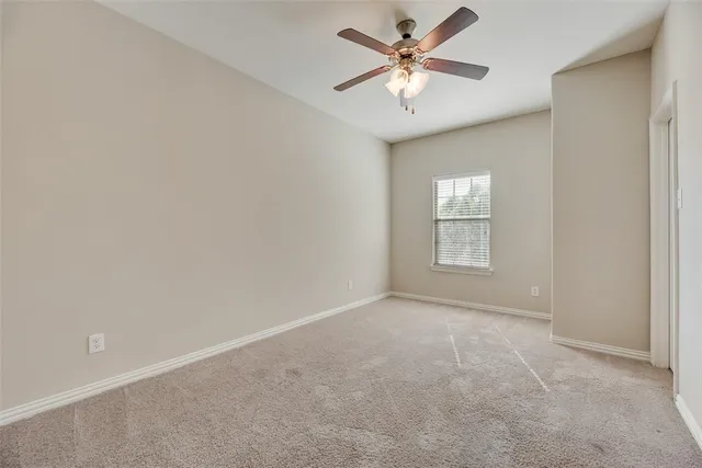 an empty room with a fan and a window