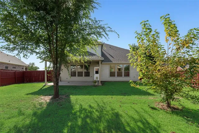 a view of a house with a yard and a tree