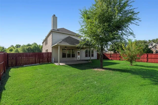 a front view of a house with a yard and trees