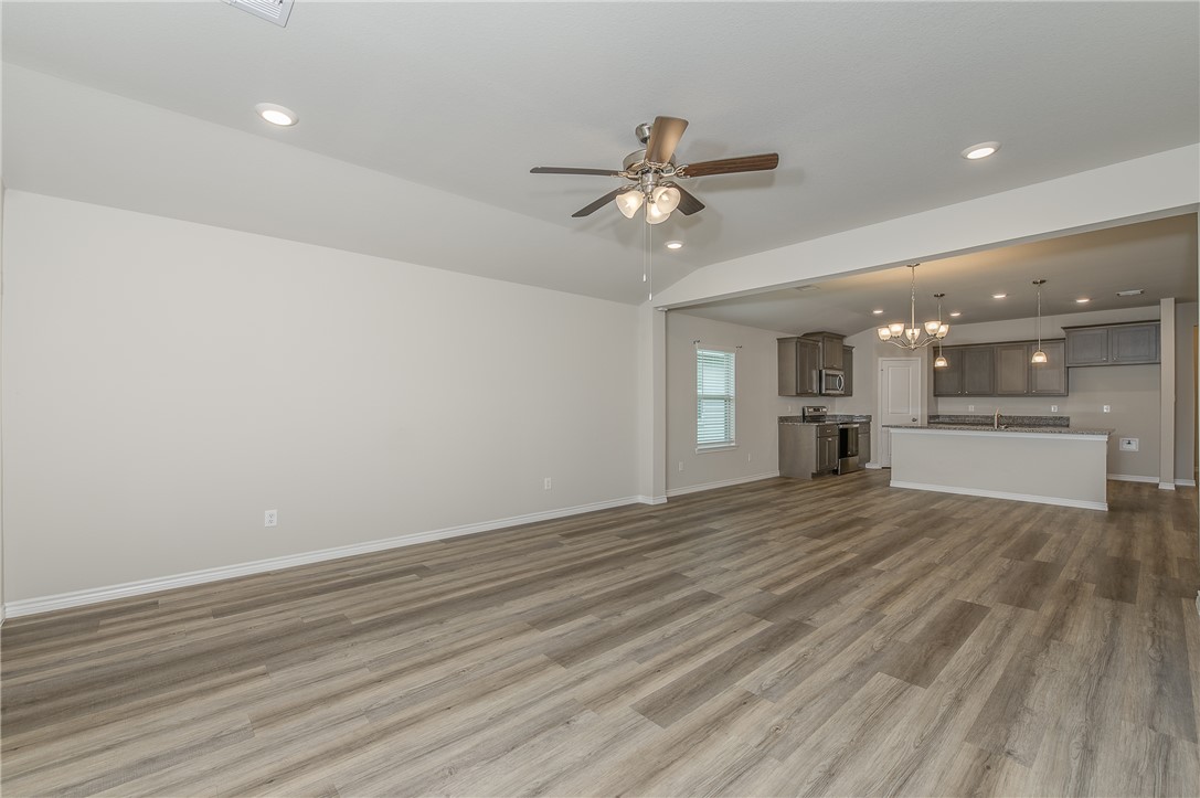 2166 Chief Street Bryan, TX 77807 - Photo 5 of 18 a view of empty room with wooden floor and kitchen view