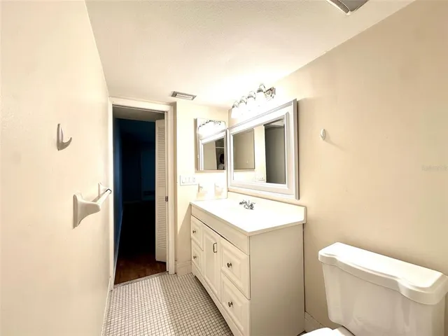 a spacious bathroom with a toilet sink and mirror