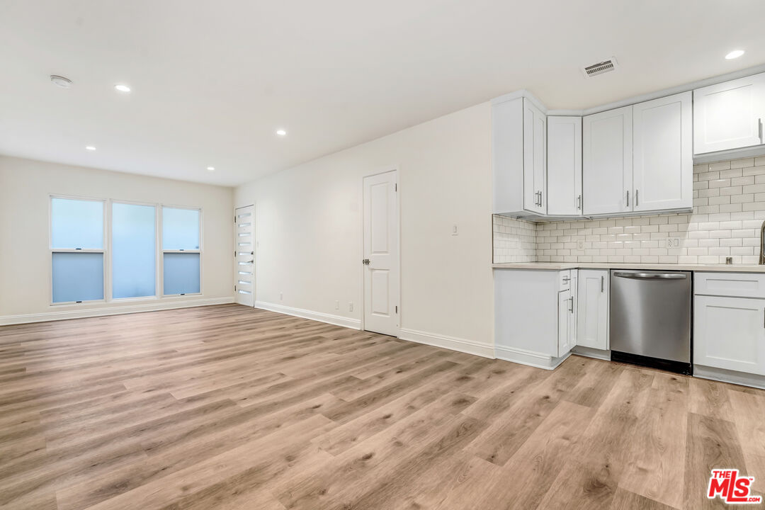a view of a kitchen with marble kitchen counter top space and stainless steel appliances