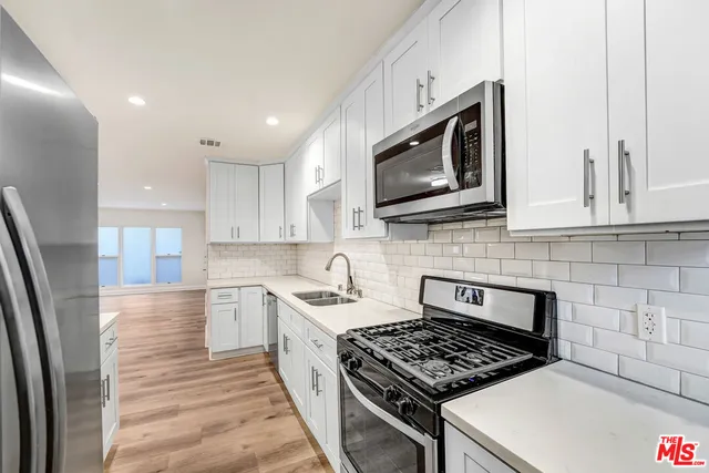 a kitchen with stainless steel appliances a stove a microwave sink and cabinets