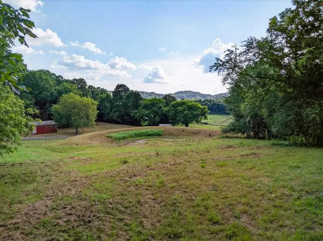 a view of a green field with wooden fence