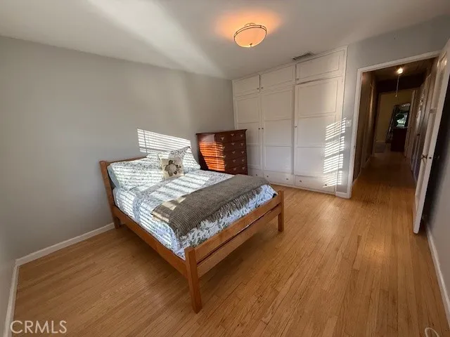 a bedroom with a bed and wooden floor