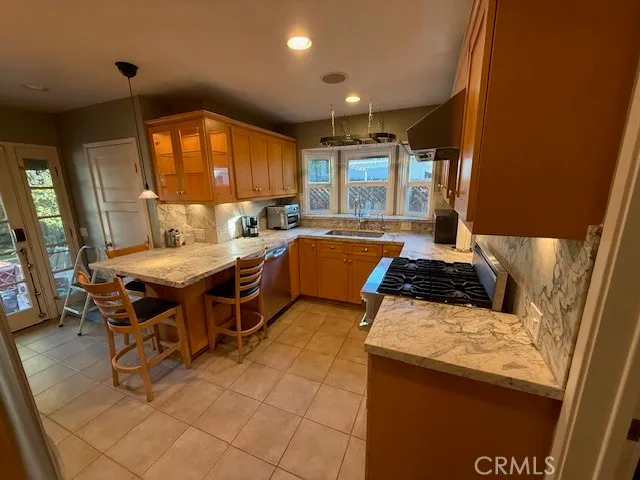 a kitchen with stainless steel appliances granite countertop a stove a sink and a microwave