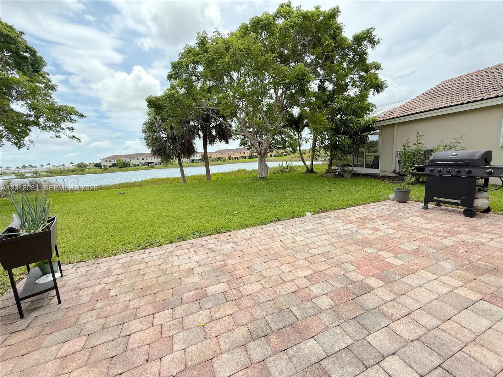 1575 Southeast 20th Road Homestead, FL 33035 - Photo 16 of 19 a view of a swimming pool and lounge chairs in the patio next to a yard