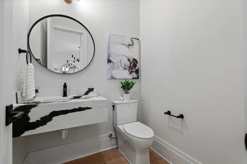 a bathroom with a granite countertop sink a toilet and shower