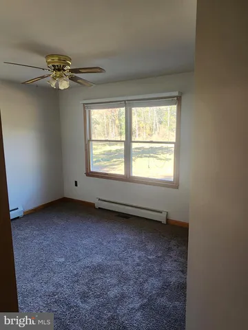 a view of a livingroom with a ceiling fan and window