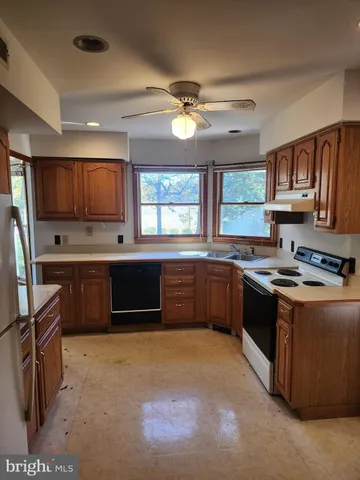 a kitchen with stainless steel appliances granite countertop a stove a sink a refrigerator a stove a oven with a dining table and chairs