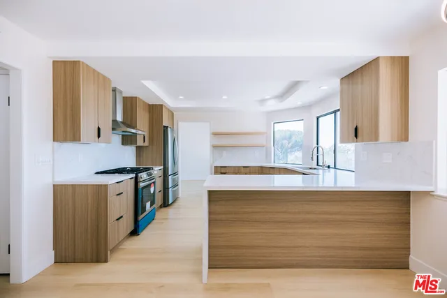 a large kitchen with kitchen island a sink a stove and a refrigerator