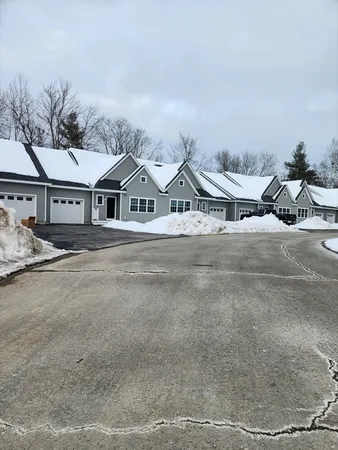 a view of a large house with a yard and parking space