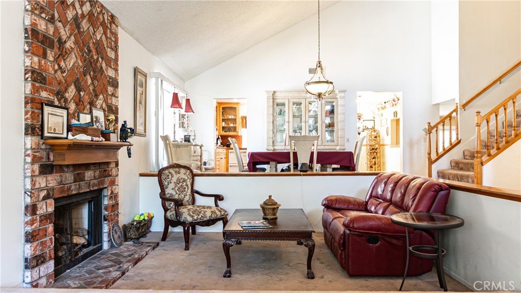 24220 Mentry Drive Newhall, CA 91321 - Photo 12 of 50 a living room with furniture a fireplace and a chandelier