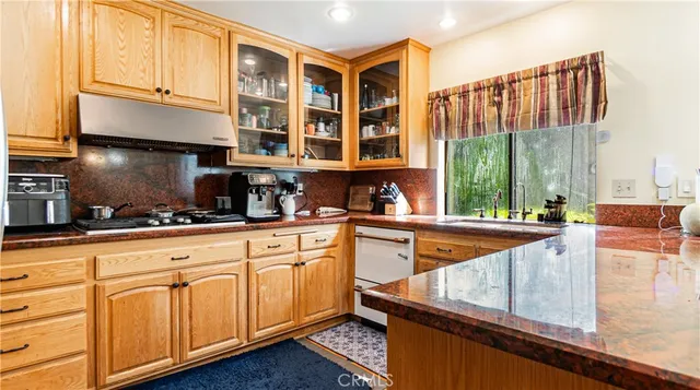 a kitchen with stainless steel appliances granite countertop a sink and cabinets