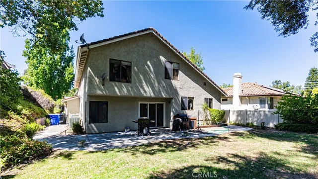 a view of a house with yard and tree in front of it
