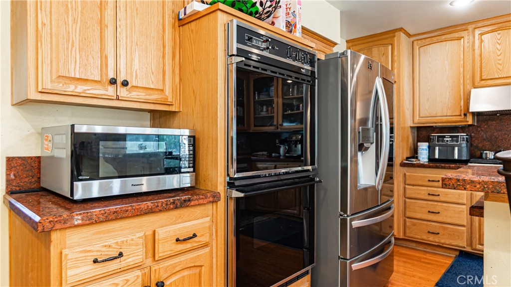 24220 Mentry Drive Newhall, CA 91321 - Photo 7 of 50 a kitchen with stainless steel appliances granite countertop a stove and a microwave