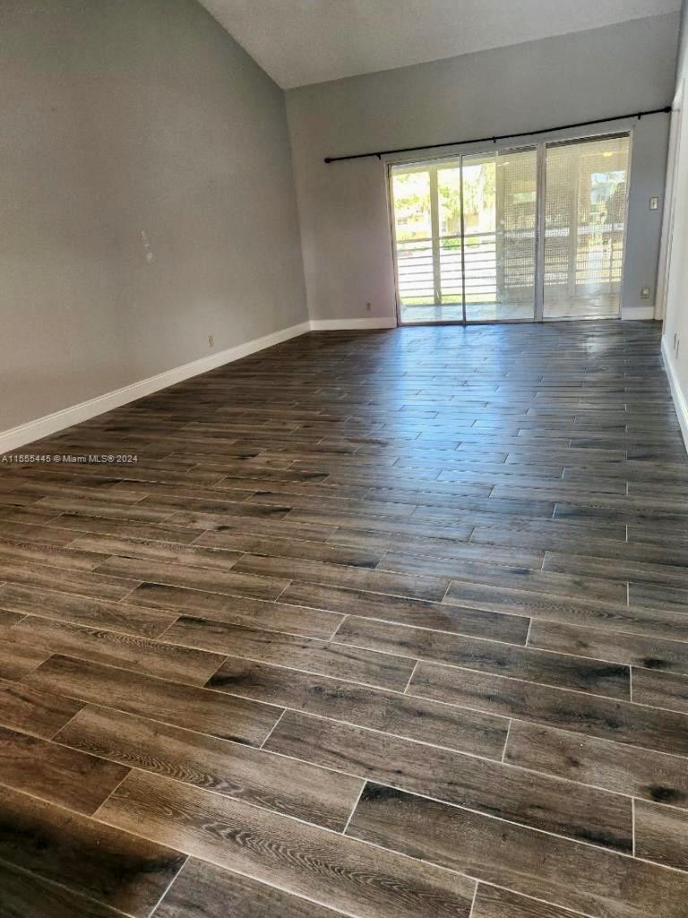 8765 Azalea Court, Unit 202 Tamarac, FL 33321 - Photo 4 of 9 an empty room with wooden floor and windows