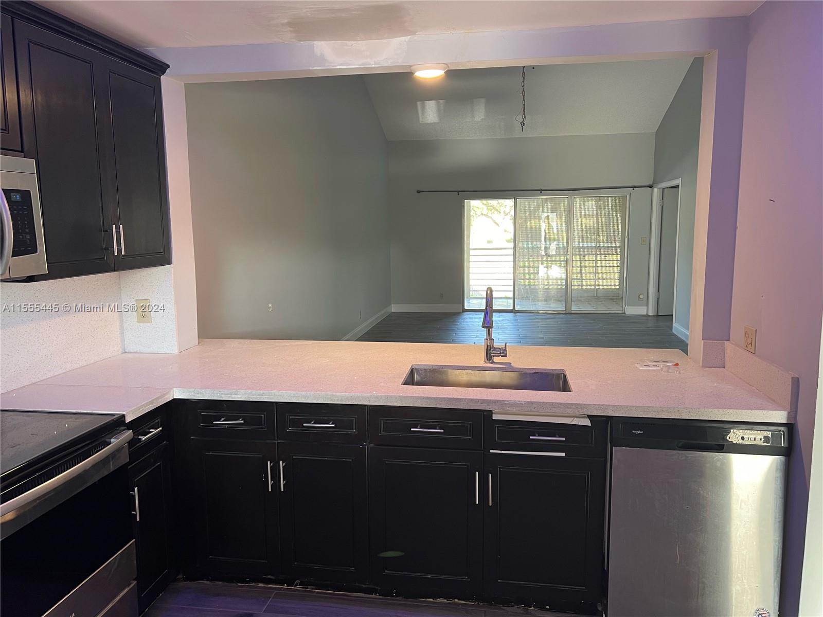 8765 Azalea Court, Unit 202 Tamarac, FL 33321 - Photo 6 of 9 a kitchen with a sink appliances and cabinets