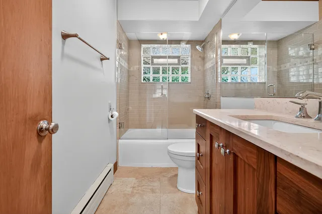 a bathroom with a granite countertop sink and a bathtub